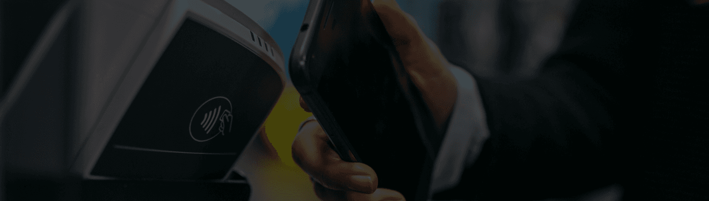 Imagem de um celular fazendo pagamento em uma maquininha